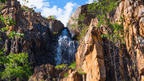 Breathtaking waterfall cascading down rocky cliffs in Australia's Top End, showcasing nature's beauty and adventure.