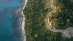 Aerial view of a winding road along Victoria's lush coastline near the Great Ocean Walk, showcasing adventure and nature.