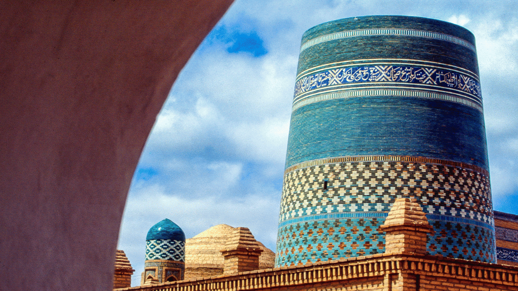 Iconic turquoise-tiled Kalta Minor Minaret in Khiva, Uzbekistan, featured on the 14-23 Day Central Asia Silk Road Tour. A must-see cultural landmark.