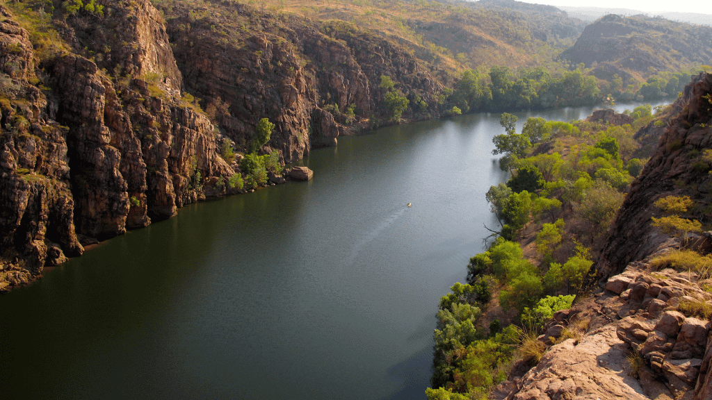 Scenic view of Nitmiluk Gorge showcasing a tranquil river and lush greenery, perfect for outdoor adventure tours.