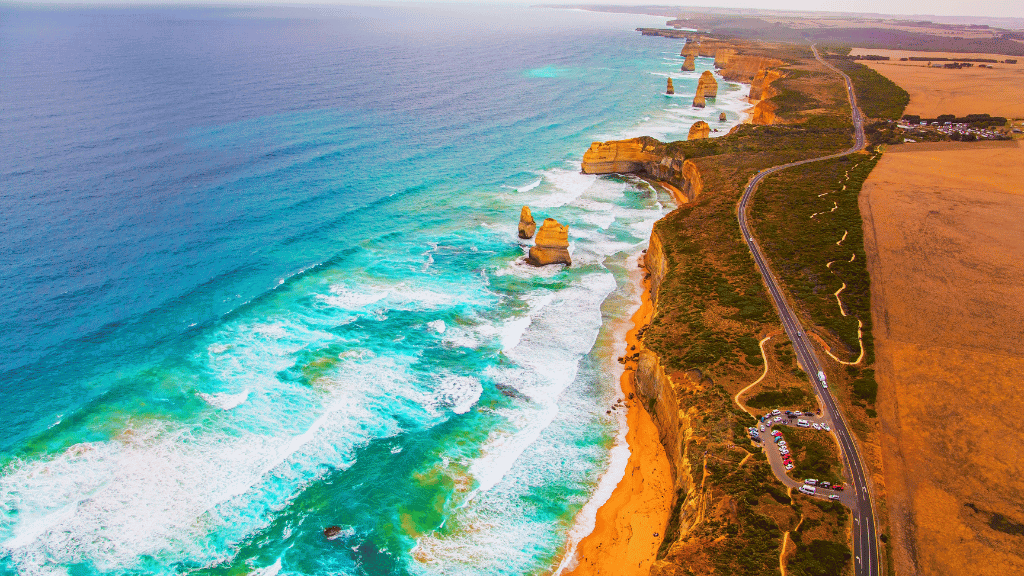 Stunning aerial view of the Twelve Apostles along the Great Ocean Walk, featuring waves and coastal cliffs.
