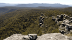 Stunning panoramic view from the Grampians, showcasing rugged cliffs and lush green forested landscapes.