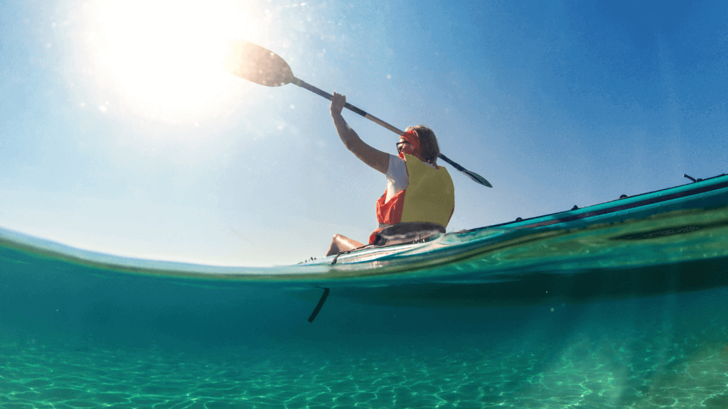 Kayaker paddling under the sun in crystal-clear waters on the Ningaloo Safari 3-Day Kayak & Snorkel Tour. Great for ocean exploration.