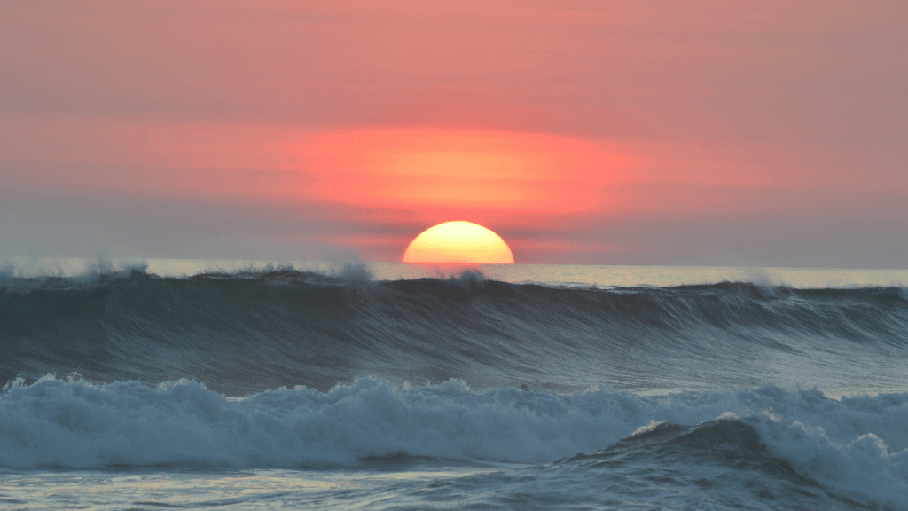 Stunning sunset over ocean waves, capturing adventure and beauty in nature's outdoors.