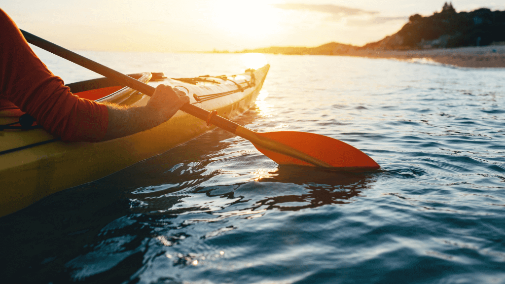 Close-up of kayaker paddling at sunset during the Ningaloo Safari 3-Day Tour. Ideal for serene ocean adventures.