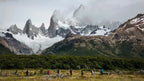Group of hikers trekking below jagged peaks in Patagonia on the Blue Heart Adventure | 9 Days. Immersive hiking experience in glacier country.