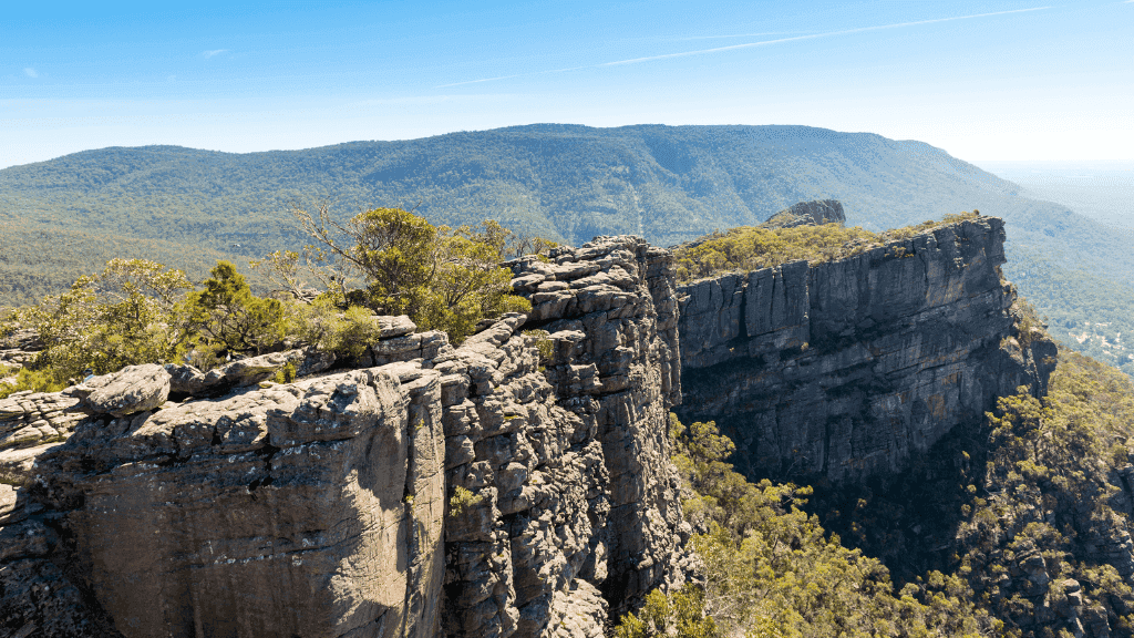 Stunning view of rugged cliffs and lush valleys in the Northern Grampians - perfect for adventure and outdoor tours.