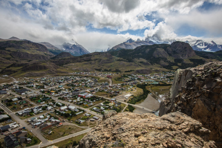 Small town nestled in a valley with mountains in the background