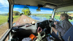 Tour guide drives through wetland road on Kakadu Katherine Gorge Tour | 4-Day Comfort Travel. Scenic journey through lush landscapes.