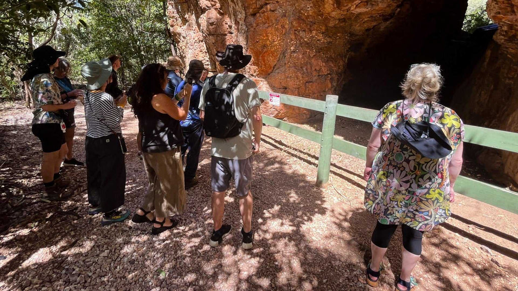 Visitors explore cave entrance on Kakadu Katherine Gorge Tour | 4-Day Comfort Travel. Discover ancient rock formations and history.