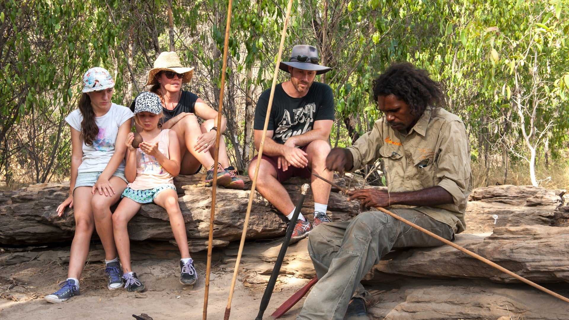 Family watches Aboriginal guide craft tools on Kakadu Katherine Gorge Tour | 4-Day Comfort Travel. Educational cultural demonstration.