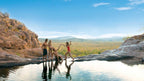 Group enjoying infinity rock pool view at Kakadu Litchfield Camping Adventure - 3-Day Tour. Scenic overlook of lush outback landscape.