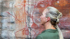 Woman observes ancient Aboriginal rock art on Kakadu Katherine Gorge Tour | 4-Day Comfort Travel. Cultural appreciation in natural setting.