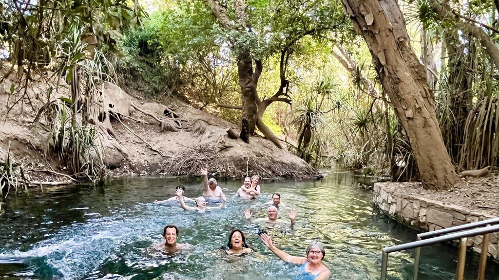 Group swims in natural thermal pool on Kakadu Katherine Gorge Tour | 4-Day Comfort Travel. Relaxing moment in lush tropical setting.