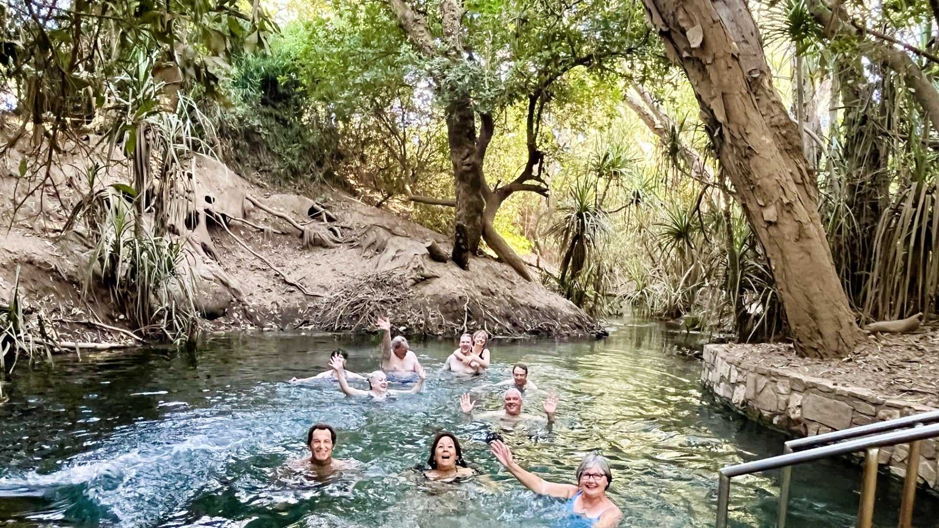 Group swims in natural thermal pool on Kakadu Katherine Gorge Tour | 4-Day Comfort Travel. Relaxing moment in lush tropical setting.