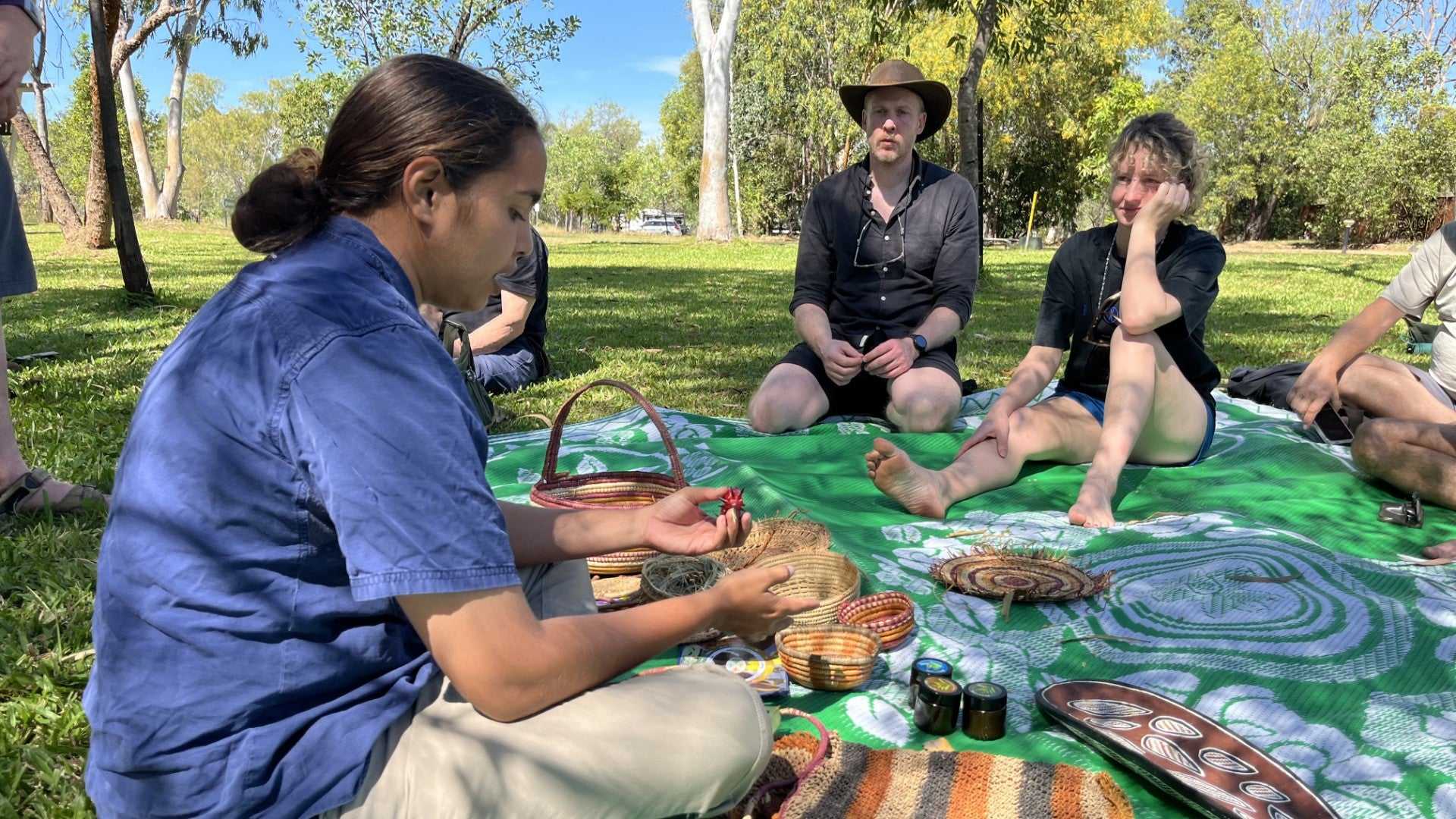 Aboriginal guide shares traditional crafts with tourists on Kakadu Katherine Gorge Tour | 4-Day Comfort Travel. Cultural immersion experience.