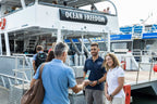 Travelers boarding Ocean Freedom boat for reef tour on East Coast Adventure 14/16-Day Small-Group Tour. Start of Great Barrier Reef excursion.