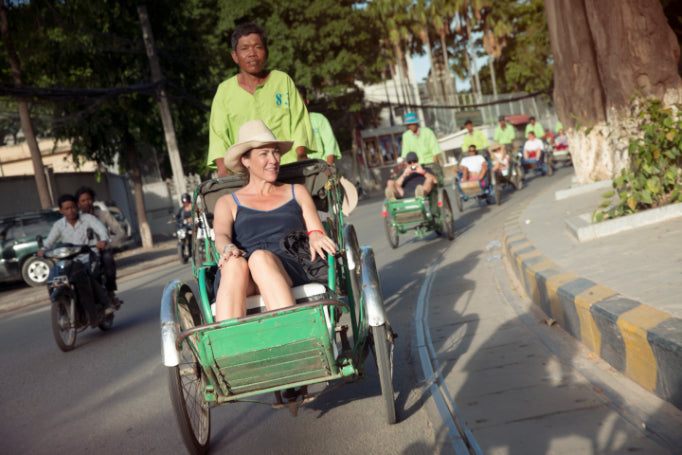 Tourist rides a cyclo through Cambodian streets, part of the local transport experience on the Angkor to Islands 16-Day Tour - Khmer Culture to Thai Coasts.