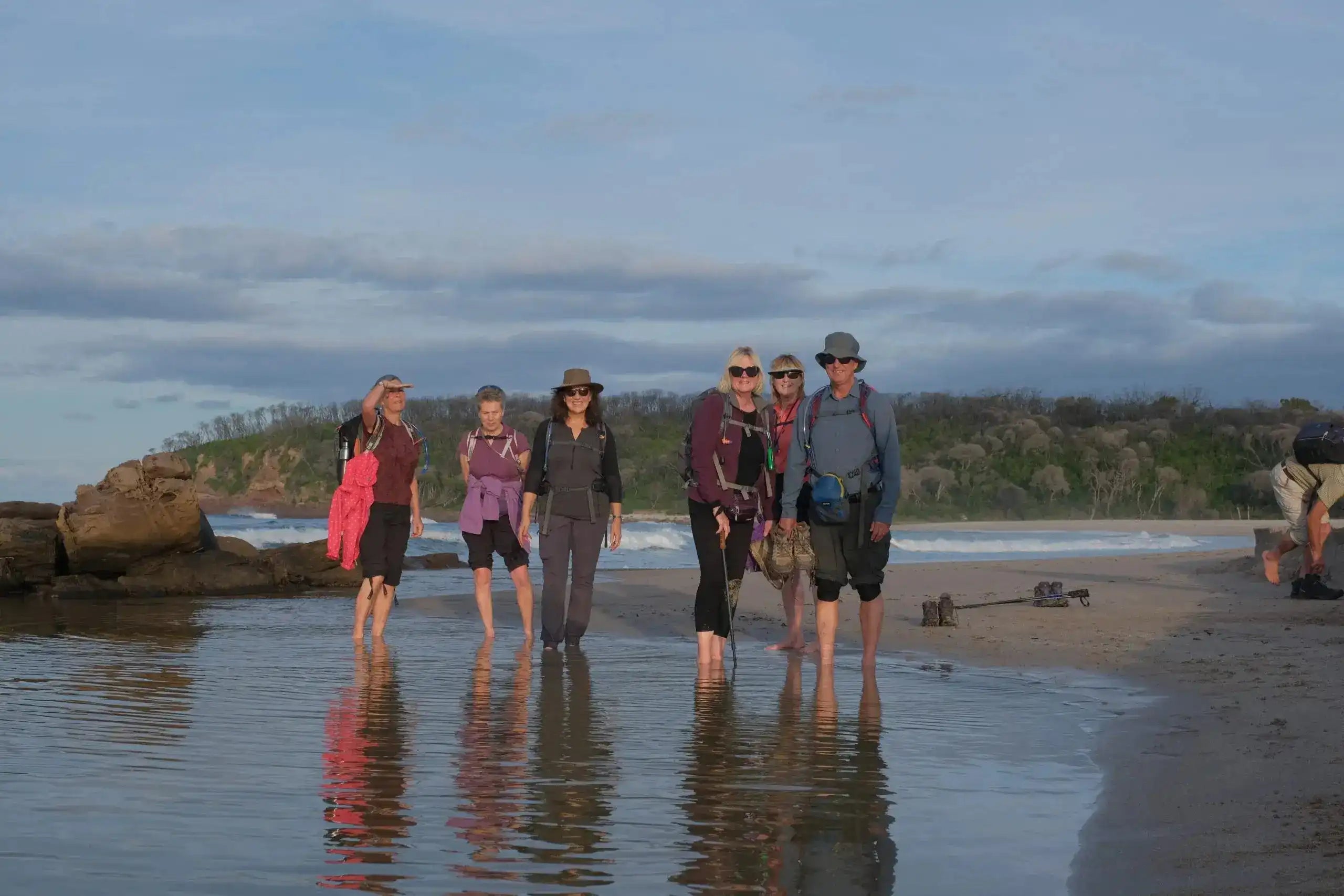 Group of people standing on a beach with a scenic background
