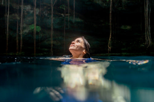 Woman floating in a cenote cave in Central America, part of the Central America Itinerary - Mexico to Panama | Travel Highlights tour.