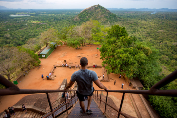 Man descending stairs at Sigiriya Rock Fortress. Explore Sri Lanka - Land & Sea Tour Options includes iconic cultural landmarks and hikes.