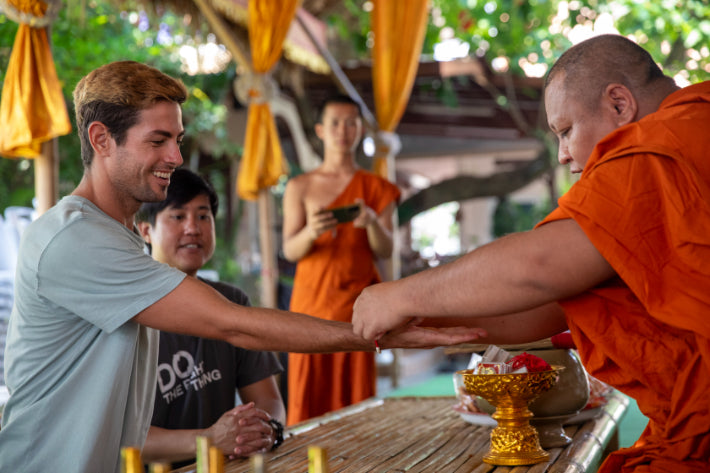 Monk blesses tourist in Thailand, a spiritual moment on the Angkor to Islands 16-Day Tour - Khmer Culture to Thai Coasts.