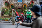 Vietnamese locals reading and relaxing near motorbikes on a street. Captures daily life during Vietnam Hiking and Cycling Tour.