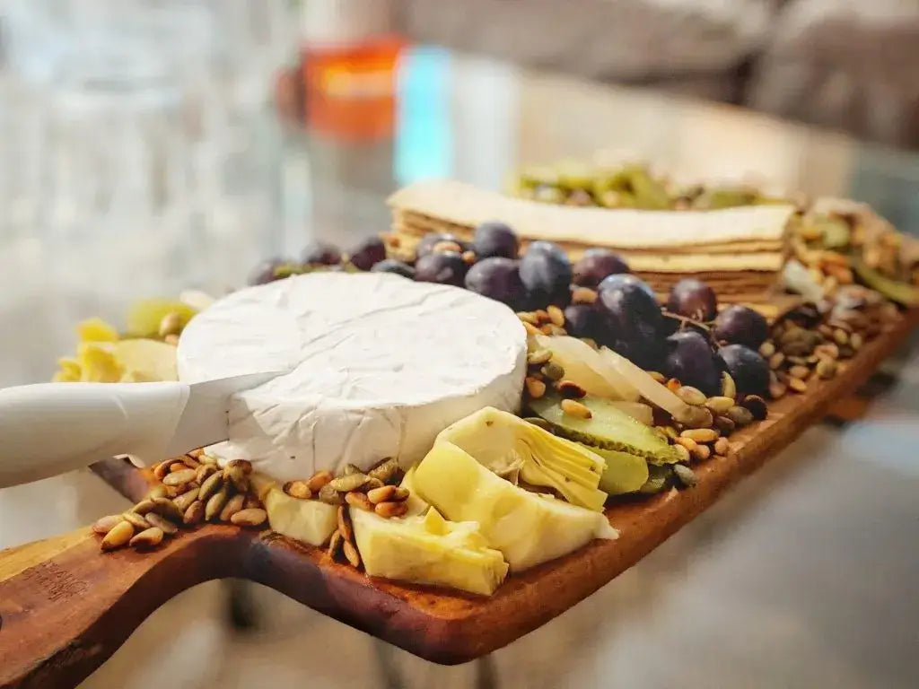 Artfully arranged charcuterie board with cheese, fruits, nuts, and crackers.