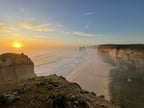 Sunset over the Twelve Apostles along the Great Ocean Walk, showcasing stunning coastal cliffs and misty waters.