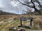 Murrays Gap sign in grassy Namadgi National Park landscape, entry point for Mt Bimberi & Blue Waterholes hike.