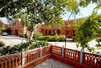 Traditional building with red brick walls and greenery in a courtyard.