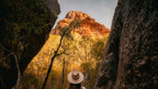 Woman looks up at towering red cliffs in Kakadu on Kakadu Katherine Gorge Tour | 4-Day Comfort Travel. Dramatic landscape exploration.