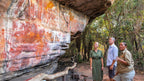Tour group viewing Aboriginal rock art at Kakadu Litchfield Camping Adventure - 3-Day Tour. Cultural experience with ancient ochre paintings.