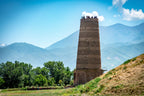 Tourists atop Burana Tower with mountain views in Kyrgyzstan, a cultural immersion stop on the 14-23 Day Central Asia Silk Road Tour.