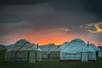 Traditional yurts at sunset in Kyrgyzstan, offering eco-friendly lodging on the 14-23 Day Central Asia Silk Road Tour.