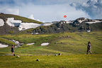Travelers hiking in alpine meadows with snow patches in Kyrgyzstan, a moderate trekking route on the 14-23 Day Central Asia Silk Road Tour.