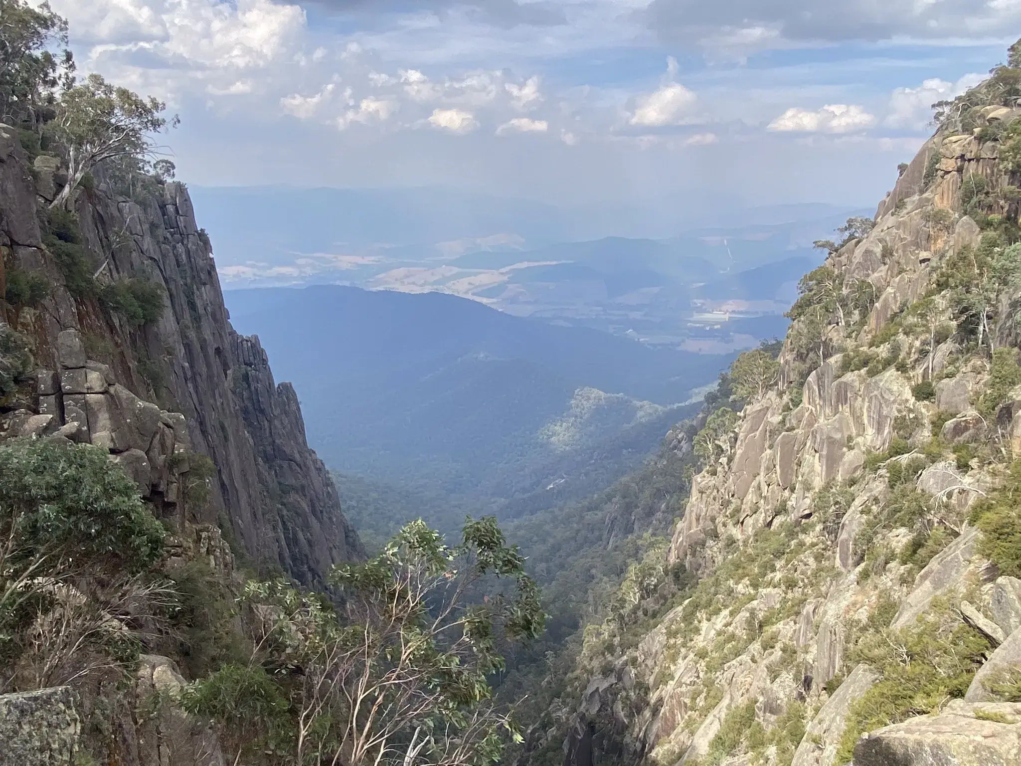 Vast mountain landscape with rugged cliffs and a serene valley view in Victoria's High Country during a hiking tour.
