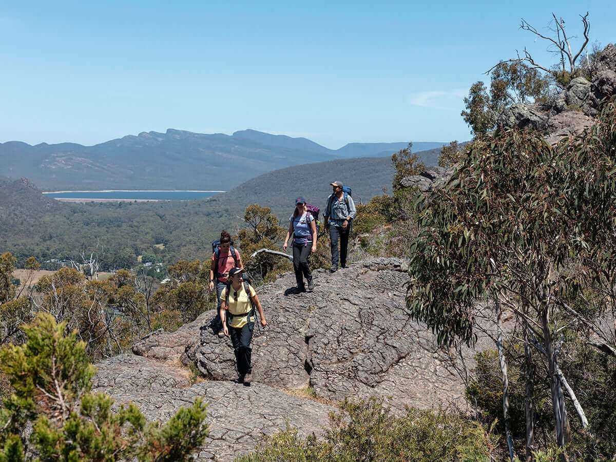 Group of hikers on rugged terrain, enjoying an outdoor adventure in the scenic Grampians.
