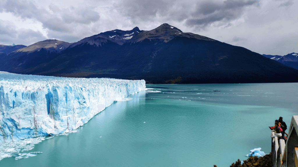 Tourists observing massive glacier from viewing platform in Patagonia on the Blue Heart Adventure | 9 Days. Glacier country exploration and photography.