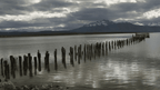 Weathered wooden pier stretching into Patagonian lake, part of the 9-day Blue Heart Adventure hiking tour. Serene stop on the Turquoise Lakes Circuit.