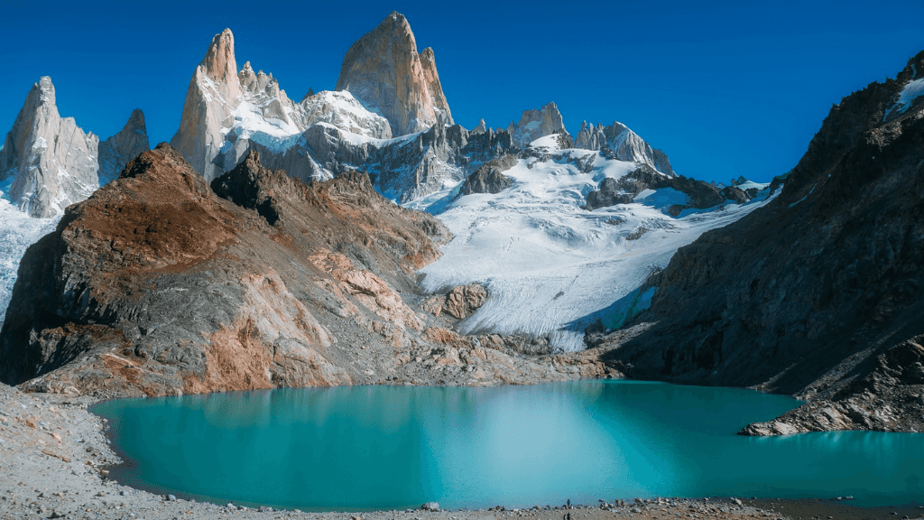 Turquoise glacial lake beneath rugged peaks in Patagonia, featured in the Blue Heart Adventure | 9 Days. Part of the Turquoise Lakes Circuit trek.