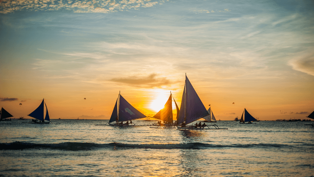 Sailboats at sunset in Boracay, romantic moment in Philippines Travel Tours - Icons of the Philippines | 10/14/23 Days.