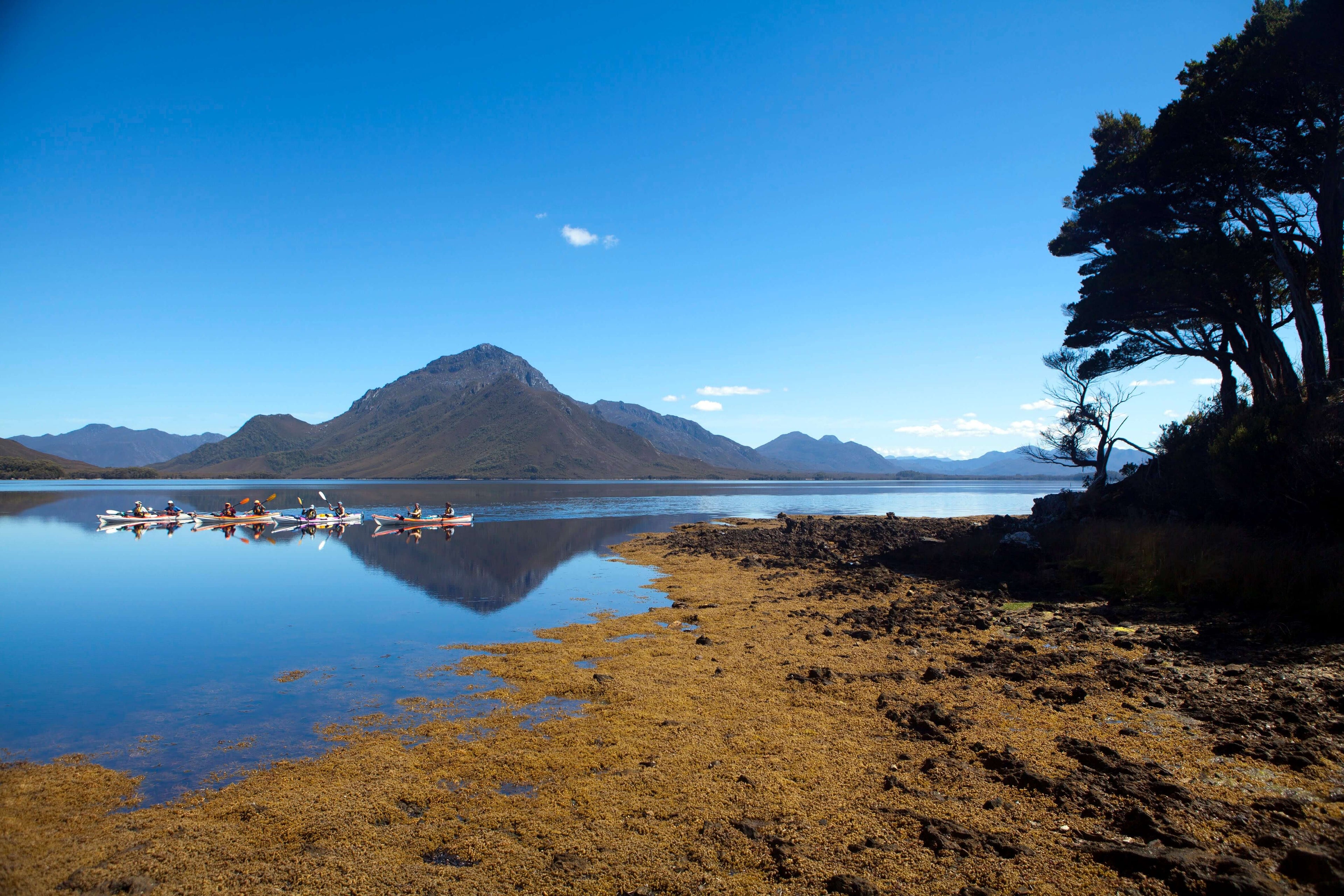 Scenic view of a lake with mountains in the background and people on boats.