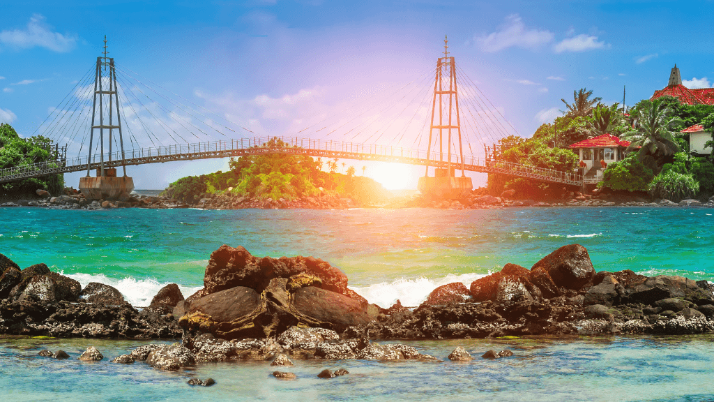 Suspension bridge over turquoise waters at sunset, a scenic coastal stop on the 12-day Sri Lanka spice gardens tour.