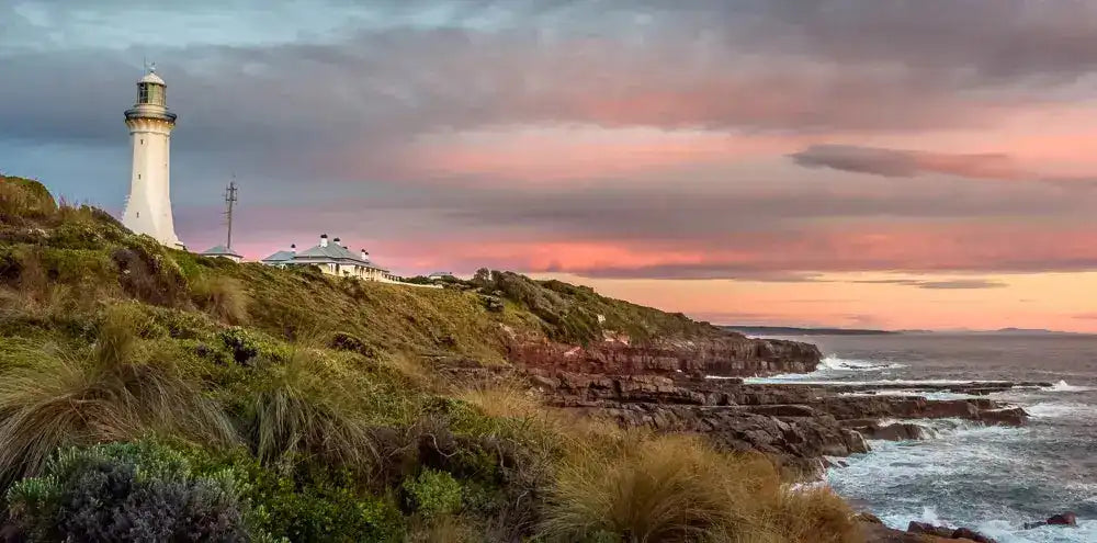 Lighthouse on a cliff with a dramatic sky over the ocean