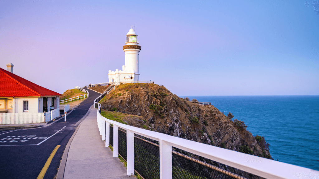 Cape Byron Lighthouse at sunrise, iconic stop on East Coast Australia tour. Scenic viewpoint on 8-day Sydney to Brisbane itinerary.