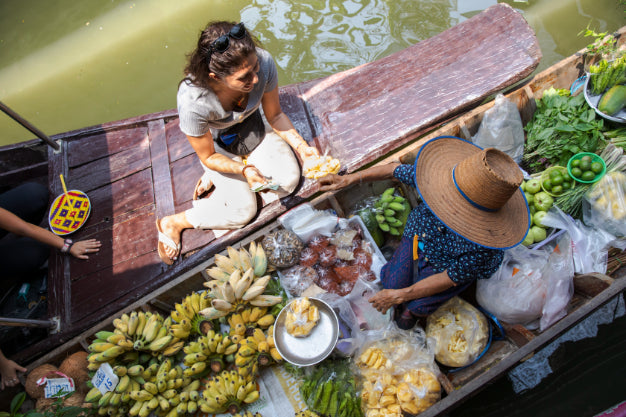 Floating market vendor sells tropical fruits, part of the local experiences on the Angkor to Islands 16-Day Tour - Khmer Culture to Thai Coasts.