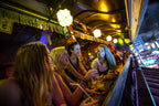 Group of women enjoy drinks at a vibrant Thai bar, experiencing nightlife on the Angkor to Islands 16-Day Tour - Khmer Culture to Thai Coasts.