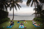 Yoga session by the sea under palm trees, a relaxing activity on the Angkor to Islands 16-Day Tour - Khmer Culture to Thai Coasts.