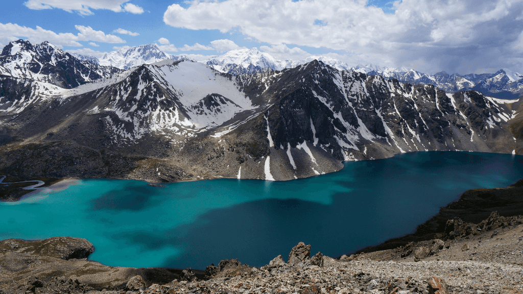 Turquoise alpine lake surrounded by snow-capped peaks in the Fann Mountains, a highlight of the Silk Road Cities Tour - Central Asia Adventure.